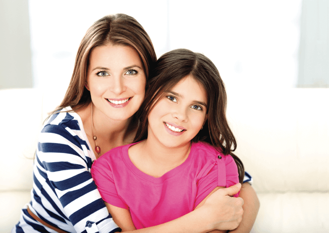 Mother and daughter smiling and hugging