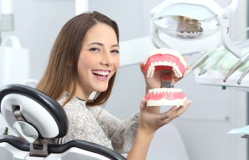 Smiling patient holding teeth mold